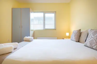 a large white bed in a room with a window at Вили Тихия Кът in Ribarica