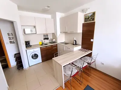 a kitchen with white cabinets and a table and chairs at Apartment in Belvedere Club G205 in Bansko