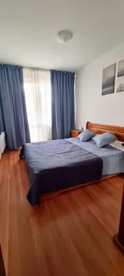 a bedroom with a large bed with blue curtains at Apartment in Belvedere Club G205 in Bansko