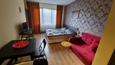 a living room with a red couch and a bed at Borovets Hills Apartments - Studio 33 in Borovets