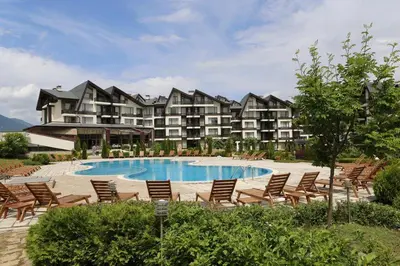 a resort with a pool and chairs and a building at Aspen Golf Resort Studio I205 in Bansko