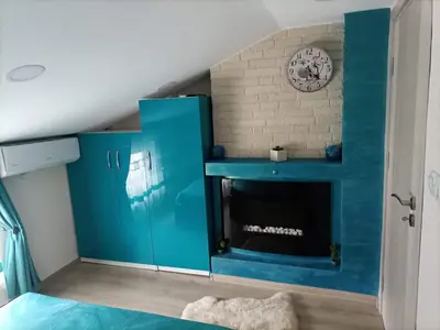 a room with a blue fireplace in a bedroom at Делоре in Sarnitsa