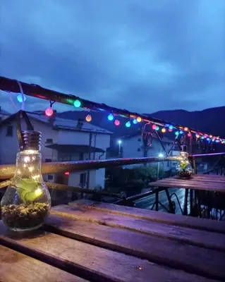 a glass jar sitting on top of a wooden bench with lights at Делоре in Sarnitsa