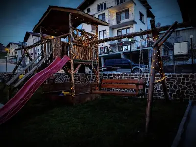 a playground in front of a house with a slide at Делоре in Sarnitsa