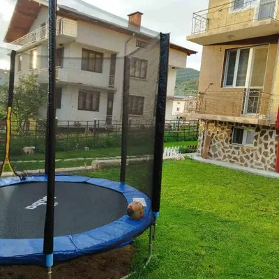 a trampoline in a yard in front of a house at Делоре in Sarnitsa