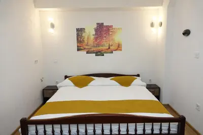 a bedroom with a bed with two paintings on the wall at Стаи за гости RADEA in Devin