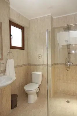 a bathroom with a toilet and a glass shower at Стаи за гости RADEA in Devin