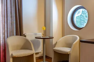 a room with two chairs and a table and a window at Вила 11 - семейна почивка в сърцето на Балкана in Ribarica