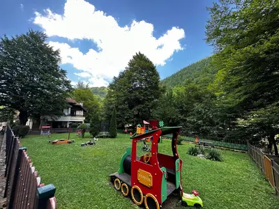 a small toy train on the grass in a yard at Вила 11 - семейна почивка в сърцето на Балкана in Ribarica
