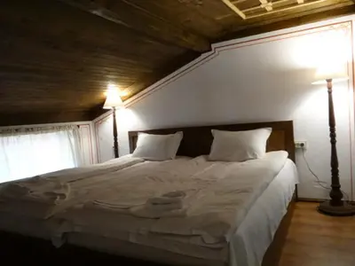 a bedroom with a large white bed with two lamps at Недкова къща in Koprivshtitsa