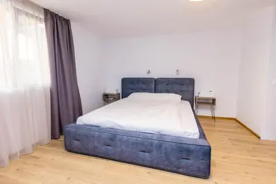 a bedroom with a large bed with a blue frame at Мезонет Пасажио in Sandanski