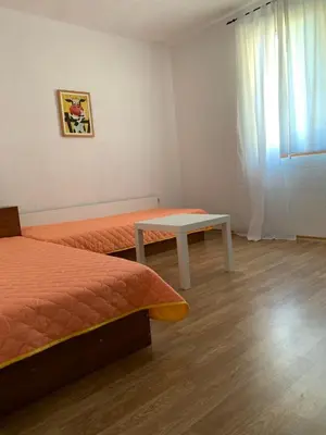 a room with two beds and a table and a window at Sunny Home in Sandanski