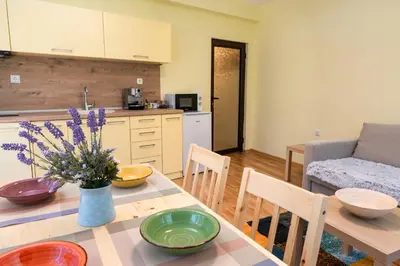 a kitchen and living room with a table with flowers on it at Bendida Park in Velingrad