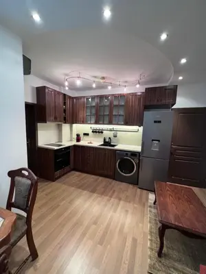a large kitchen with wooden cabinets and a table and a tableablish at Dalv Residence - SPA Fairy Tale in old Sofia in Sofia