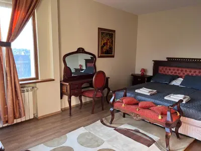 a bedroom with a bed and a desk and a mirror at Dalv Residence - SPA Fairy Tale in old Sofia in Sofia