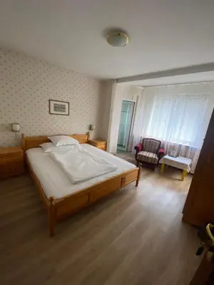 a bedroom with a large bed and a living room at Family Hotel Zdravets in Sofia