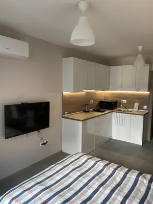 a kitchen with white cabinets and a bed in a room at Movie flats in Sofia