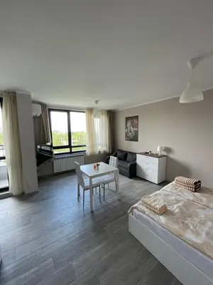 a bedroom with a bed and a table in a room at Movie flats in Sofia