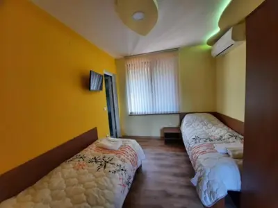 two beds in a room with yellow walls at Райчевата къща - Кюстендил in Kyustendil