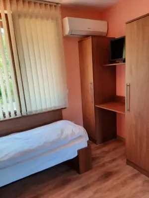a small room with a bed and a window and a cabinet at Райчевата къща - Кюстендил in Kyustendil