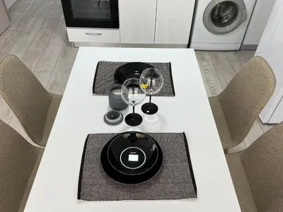 a white table with two chairs and wine glasses on it at Апартамент Панорама Рози in Sandanski