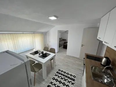 a kitchen with a white table and chairs in a room at Апартамент Панорама Рози in Sandanski