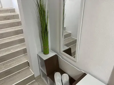 a vase sitting on a shelf next to a mirror at Апартамент Панорама Рози in Sandanski