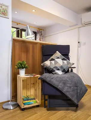 a bedroom with a bed and a table with a lamp at Peaceful Riverside Studio with private Garden Center Parking in Plovdiv