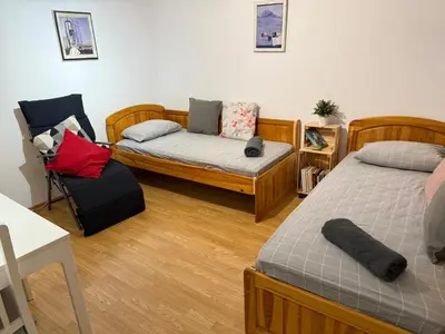 a living room with two beds and a chair at Peaceful Riverside Studio with private Garden Center Parking in Plovdiv
