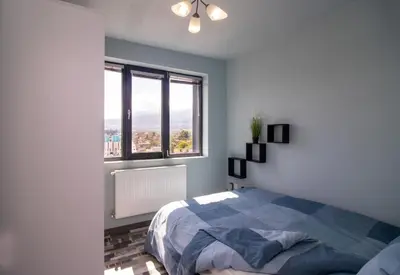a bedroom with a bed and a large window at Mountain View Apartment 1 + Parking in Sofia