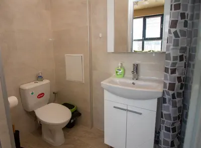 a bathroom with a toilet and a sink and a mirror at Vitosha View Apartment with Parking in Sofia