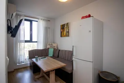 a living room with a couch and a table and a refrigerator at City View Apartment + Parking in Sofia