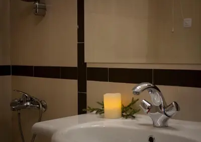 a bathroom sink with a candle and a mirror at GO GO Holiday in Borovets