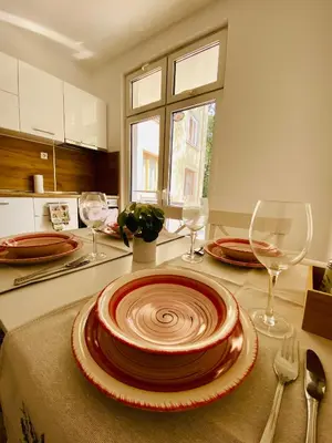a kitchen with a table with plates and wine glasses at City Center 2-bedroom cosy apartment in Plovdiv