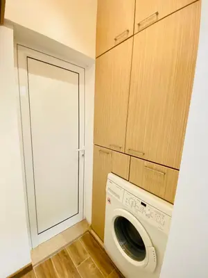 a laundry room with a washing machine and cabinets at City Center 2-bedroom cosy apartment in Plovdiv