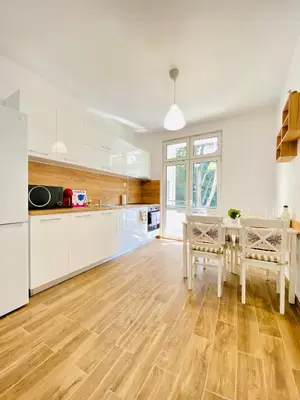 a kitchen with white cabinets and a table with chairs at City Center 2-bedroom cosy apartment in Plovdiv