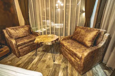 a living room with two chairs and a table at Вила АМРИТА in Tsigov Chark
