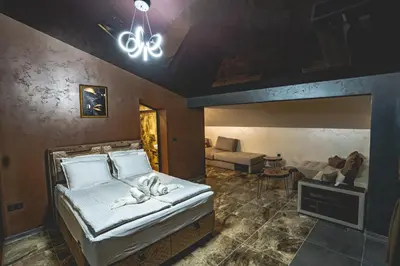 a bedroom with a bed and a living room at Вила АМРИТА in Tsigov Chark