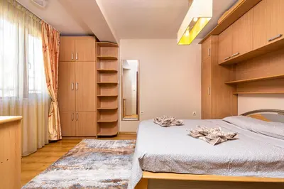 a bedroom with a bed and wooden cabinets at Centrally-located 1BD Apartment near Kapana by Flat Mаnager in Plovdiv