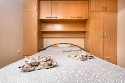 a bedroom with a bed with wooden cabinets at Centrally-located 1BD Apartment near Kapana by Flat Mаnager in Plovdiv