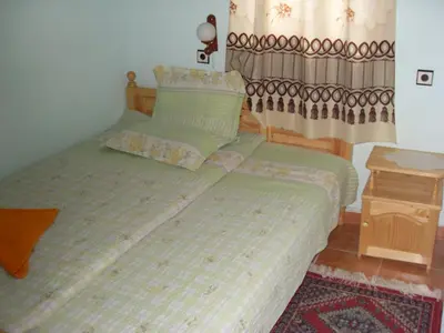 a bedroom with two twin beds and a table at Guest House Rimski Most in Melnik