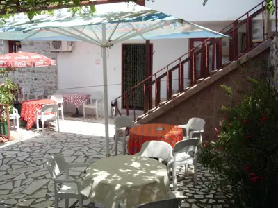 a patio with a table and chairs and an umbrella at Guest House Rimski Most in Melnik