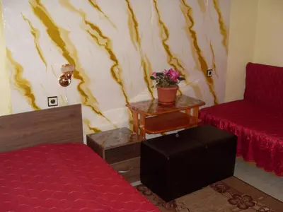 a room with a bed and a chair and a table at Guest House Rimski Most in Melnik