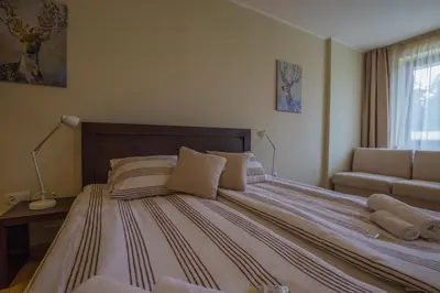 a bedroom with a large bed and a couch at Euphoria Club and Resort Rental in Bŭrduche