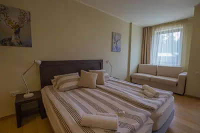 a bedroom with a large bed and a couch at Euphoria Club and Resort Rental in Bŭrduche