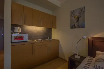 a kitchen with wooden cabinets and a sink next to a bed at Euphoria Club and Resort Rental in Bŭrduche