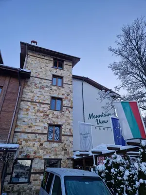 a building with a car parked in front of it at Mountain View Resort - Apartment B45 in Bansko