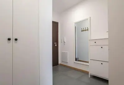 a room with white cabinets and a mirror and a door at 