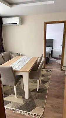 a dining room with a table and a couch at ORION APARTMENTS in Chepelare