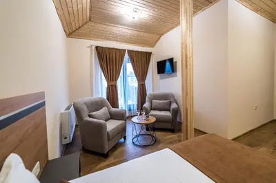 a bedroom with two chairs and a table in a room at Слънчевите Къщи in Banya